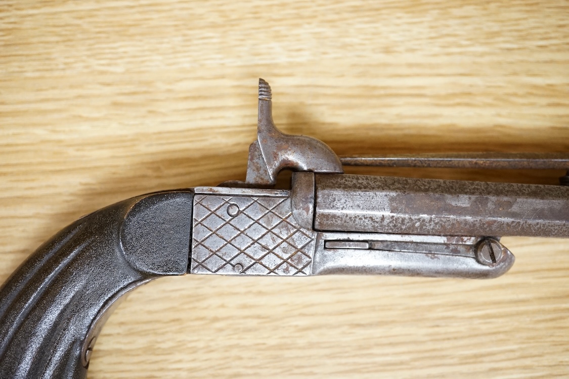 A 20th century double barrel pinfire pistol with sprung bayonet, box lock action, and fluted wooden grip